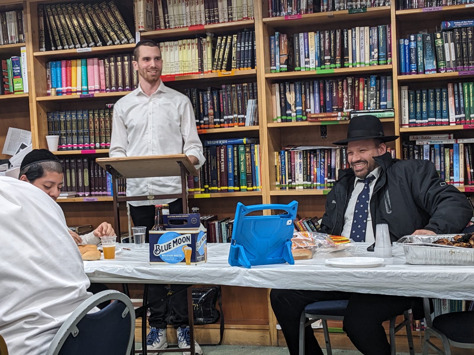 A talmid speaking at a shtender in the yeshiva library