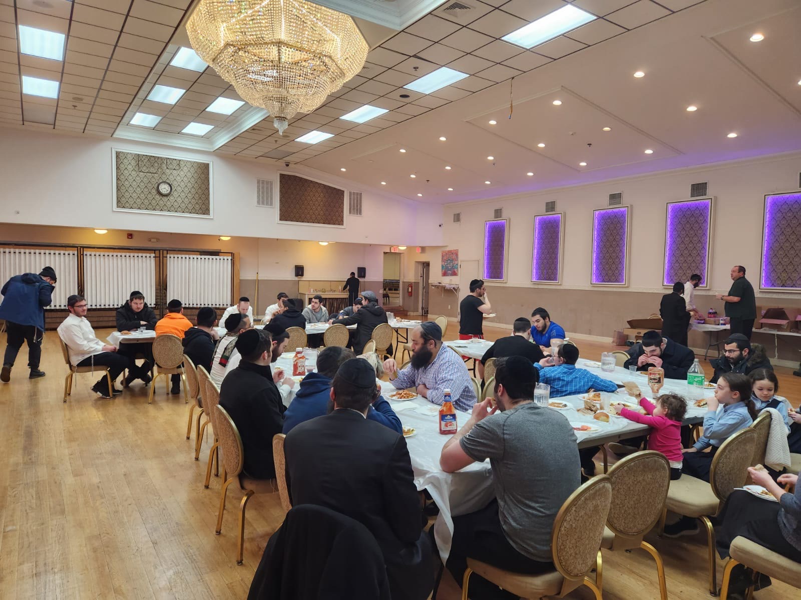 Talmidim and families eating together in a large hall