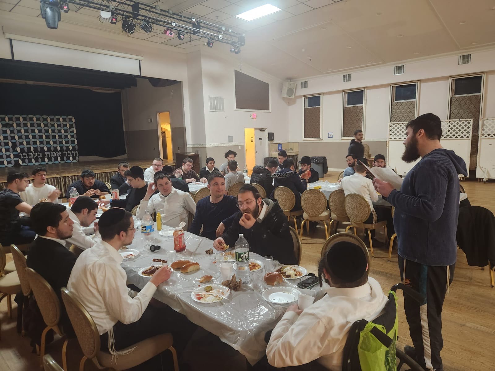 Talmidim eating together at tables in the hall