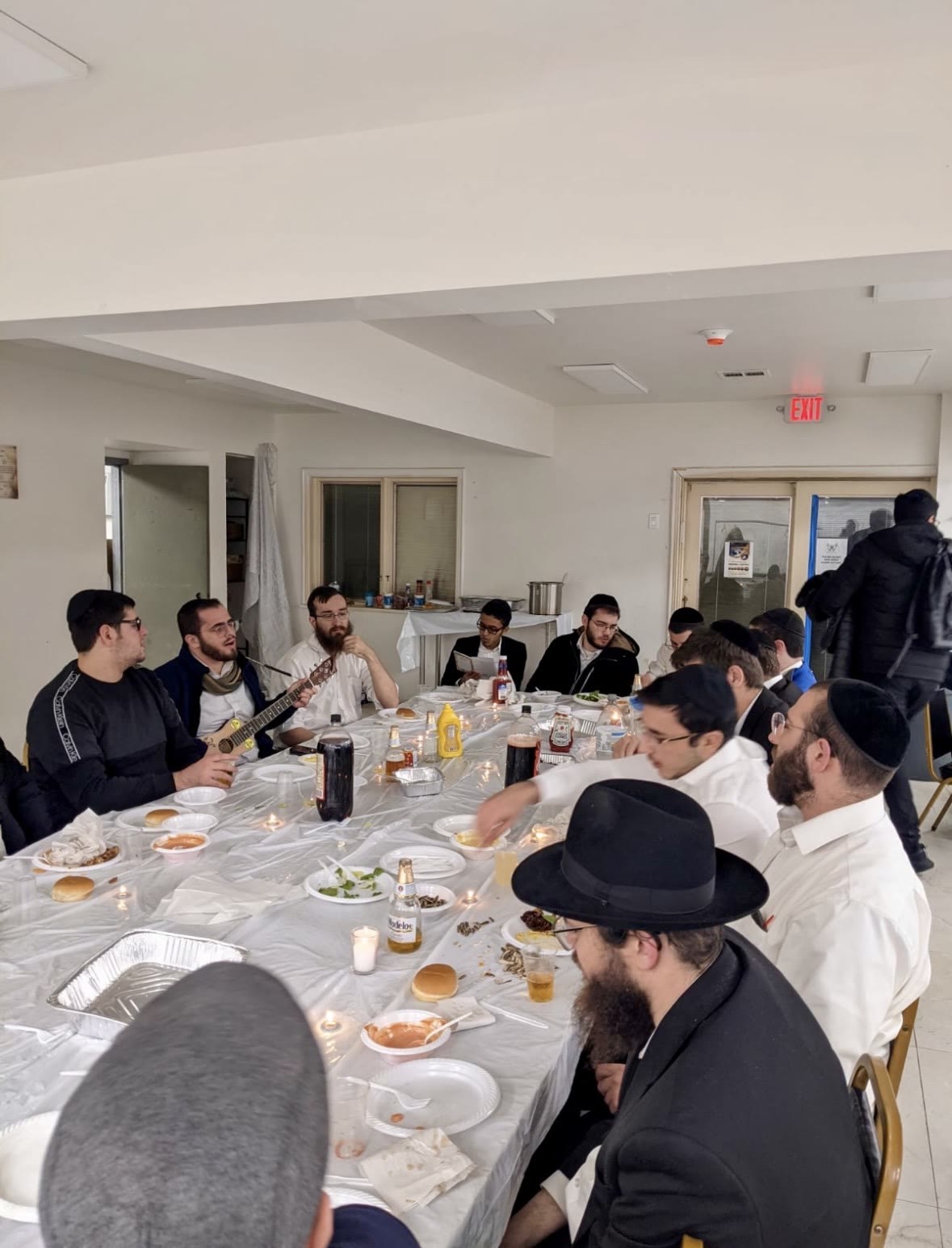 Talmidim listening as one plays guitar at the table