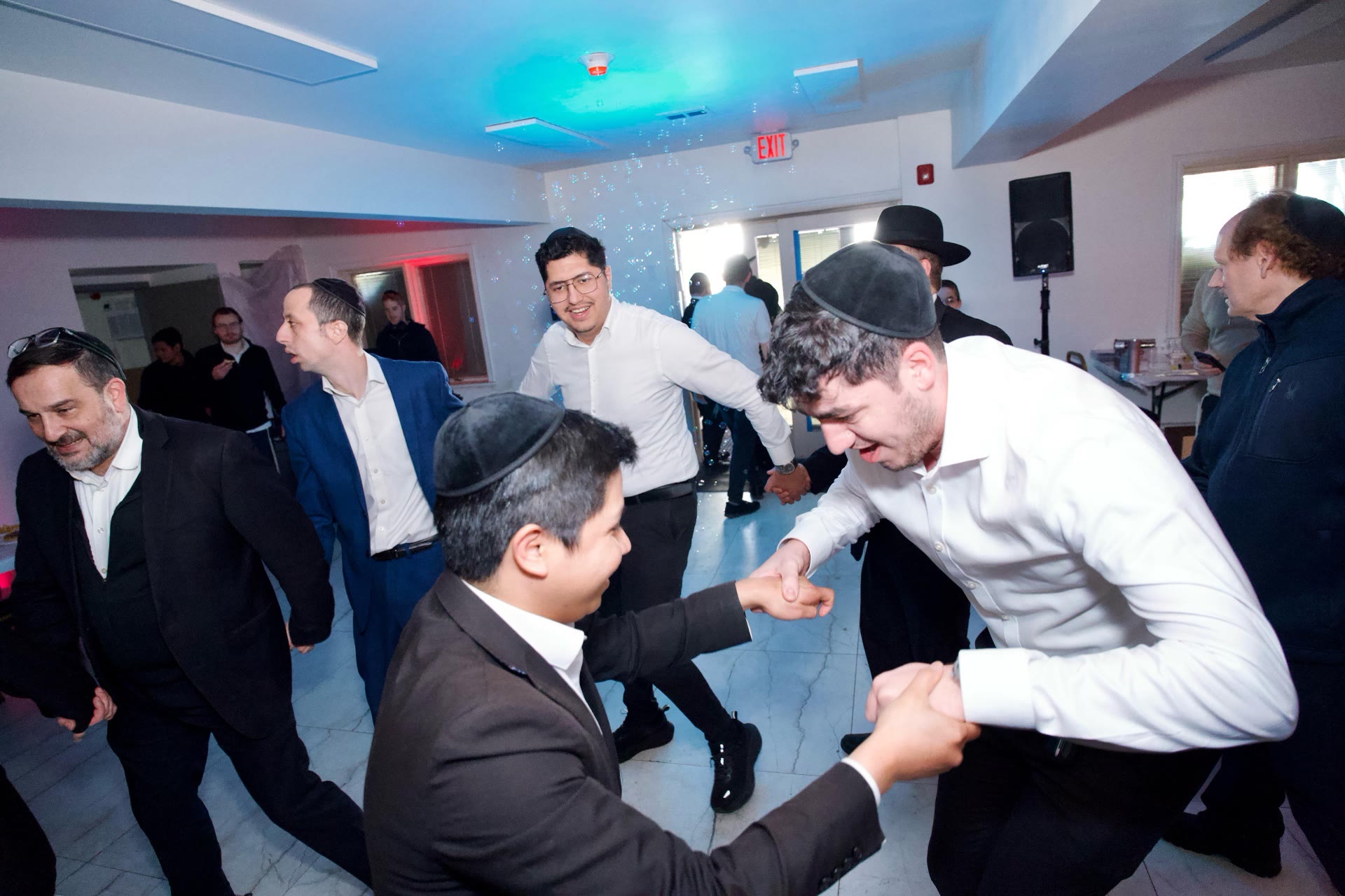 Talmidim dancing together under coloured lights
