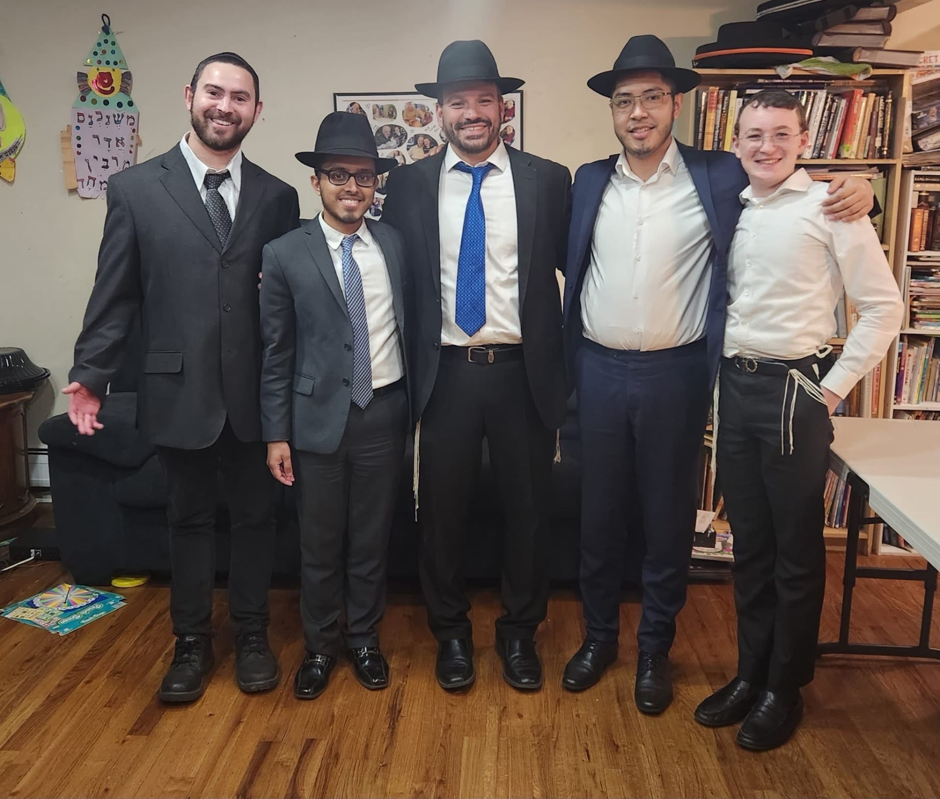 Five talmidim posing together in a rebbe's home