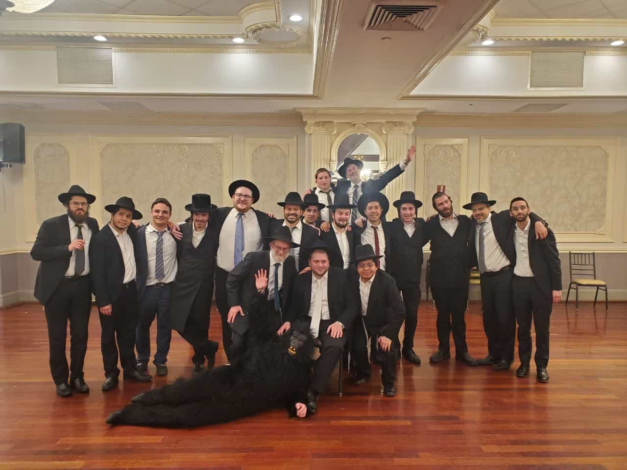 Talmidim and rebbeim posing together in a hall
