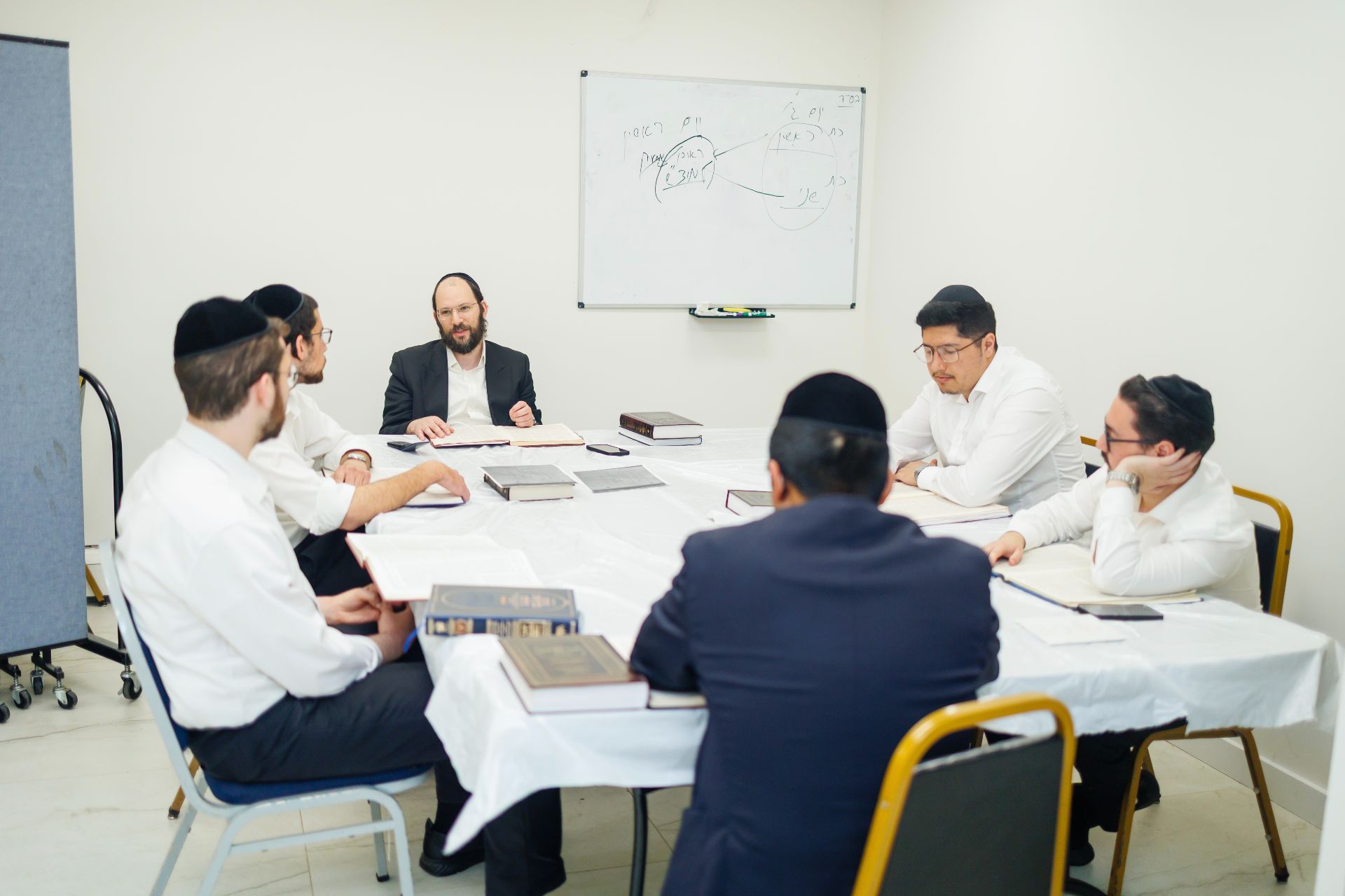 A rebbe delivering a shiur to talmidim in a Toras Dovid classroom