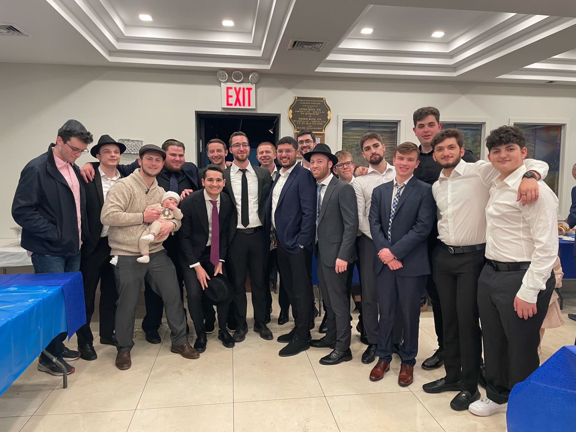 Talmidim posing together at a celebration in a hall