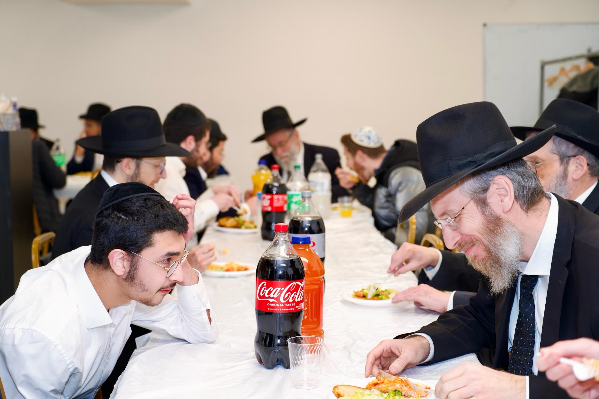 A rebbi and a talmid in conversation over a meal