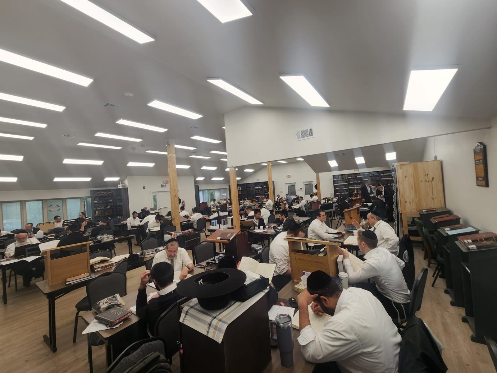 Talmidim learning at shtenders and tables across the beis medrash