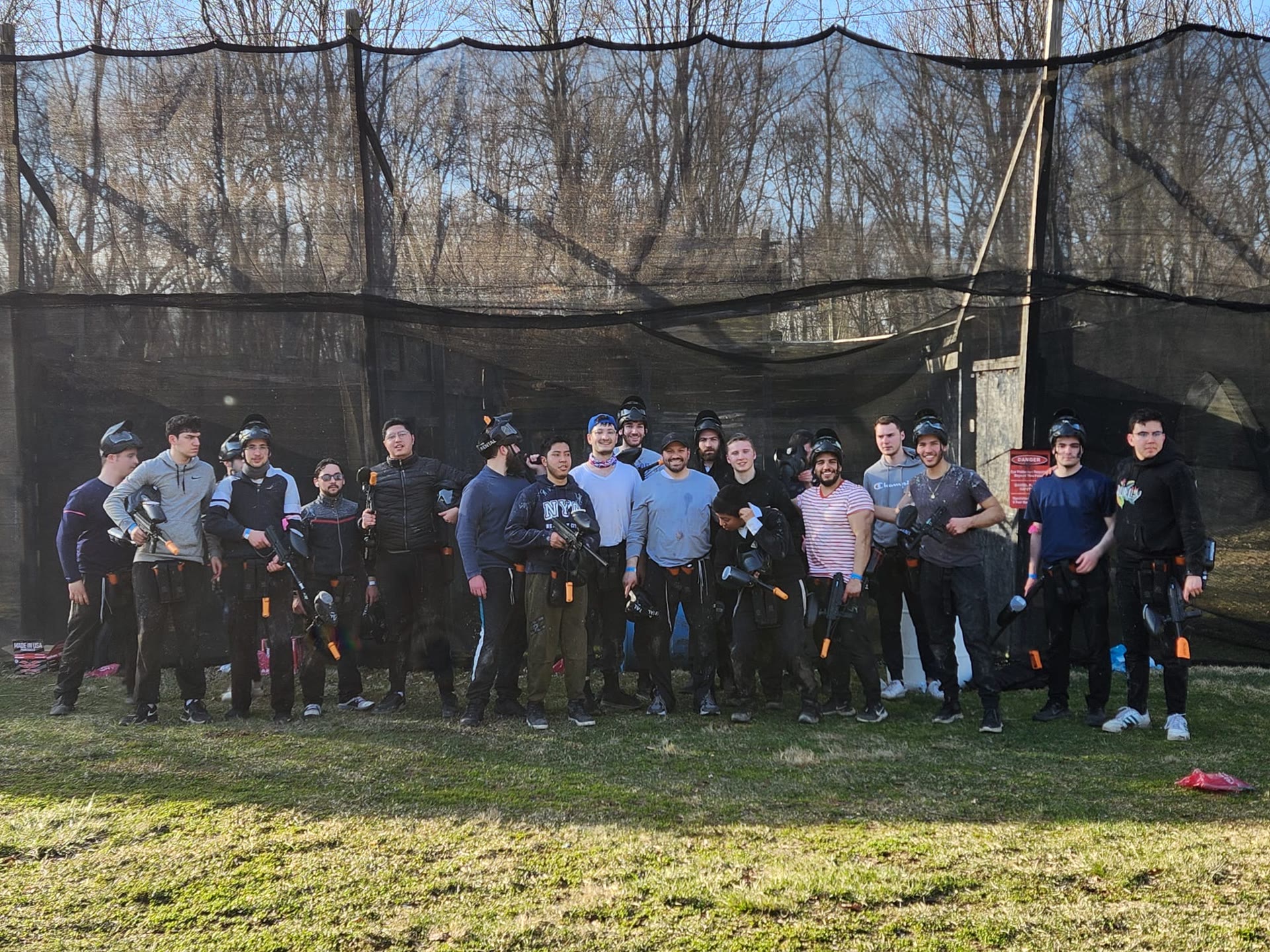 Talmidim posing with gear at an outdoor paintball field