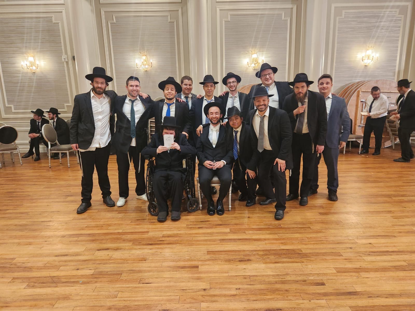 Talmidim posing together on the dance floor of a hall