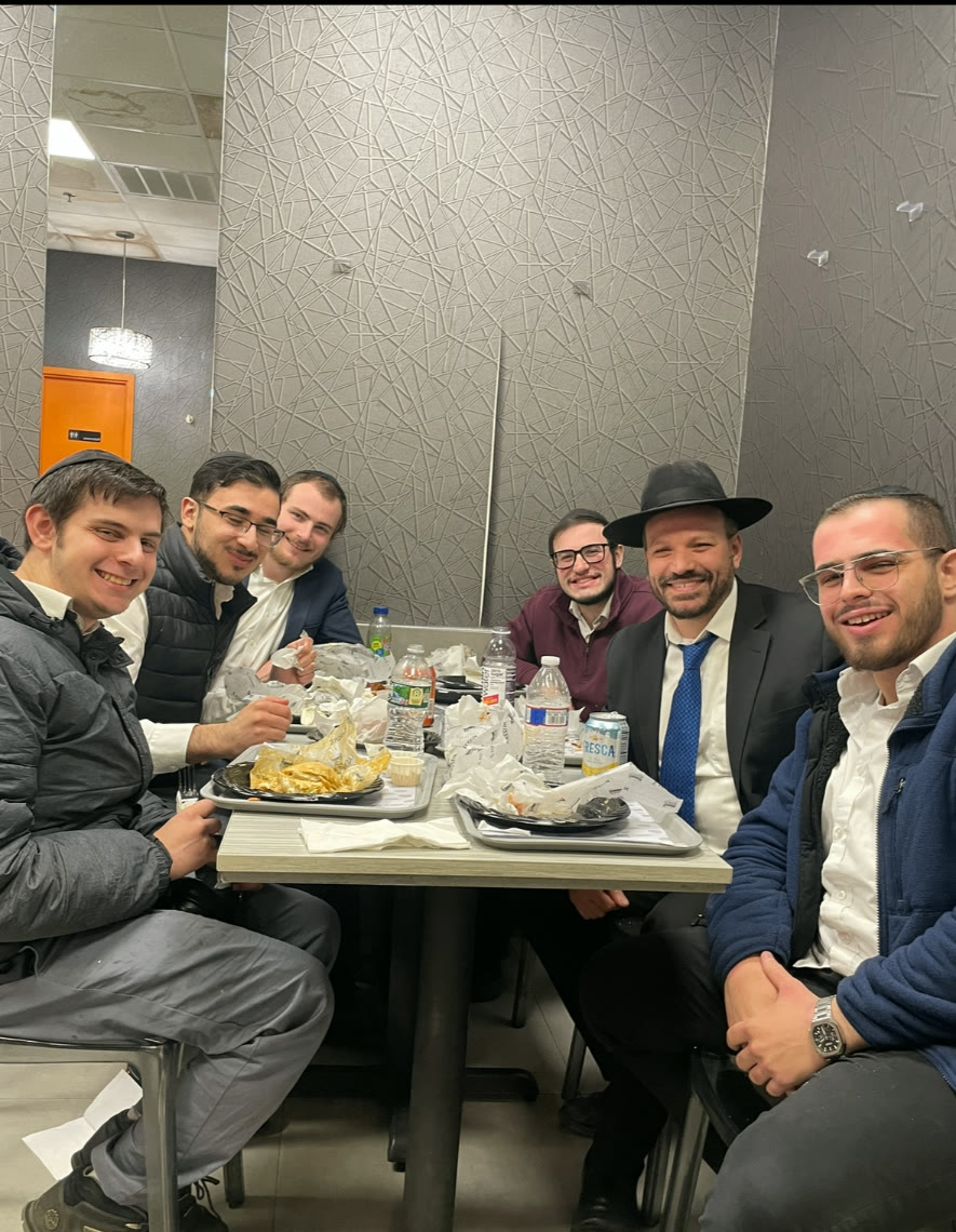 Talmidim sitting around a table together at a meal out