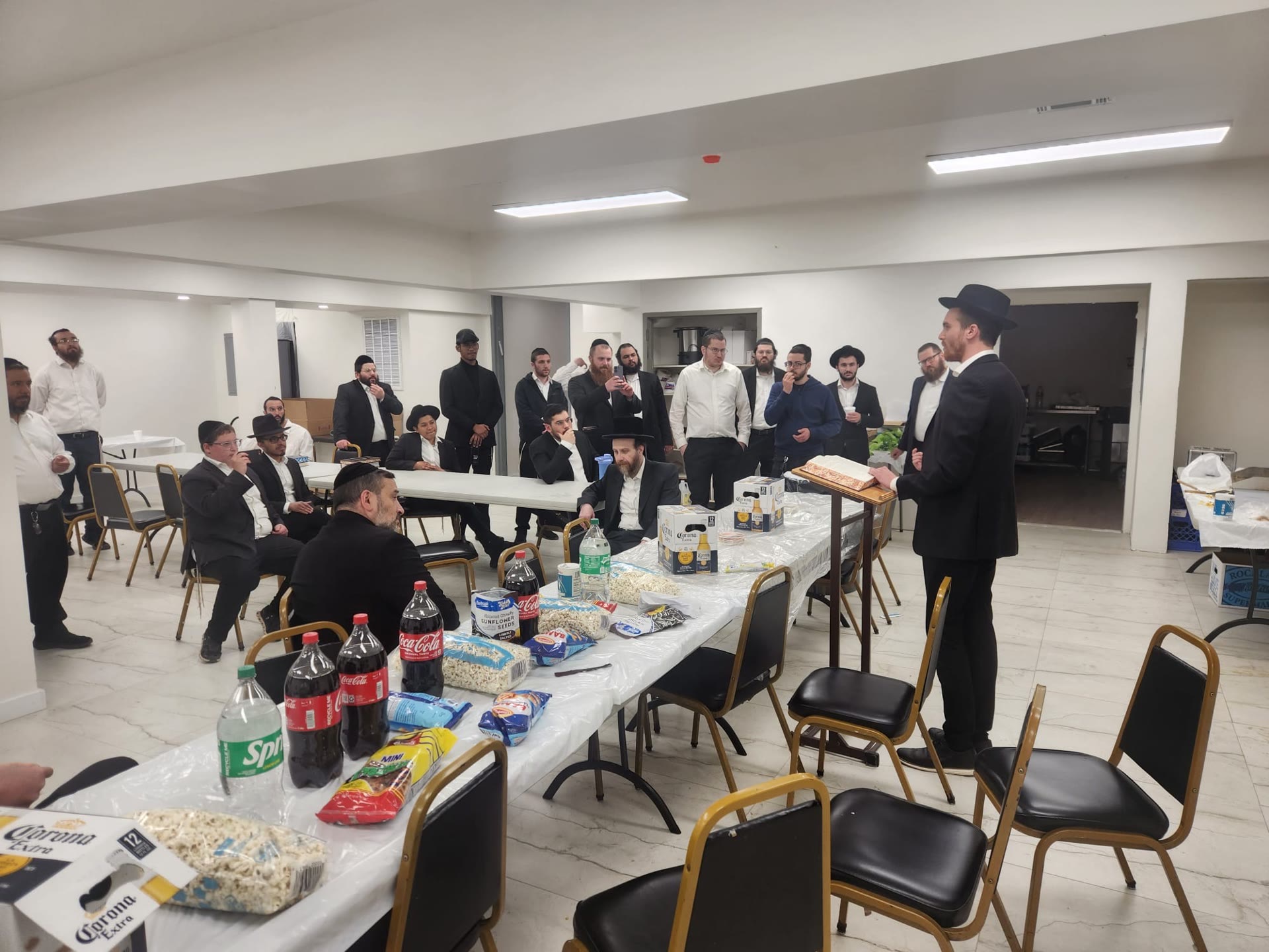 A speaker addressing talmidim gathered in the hall
