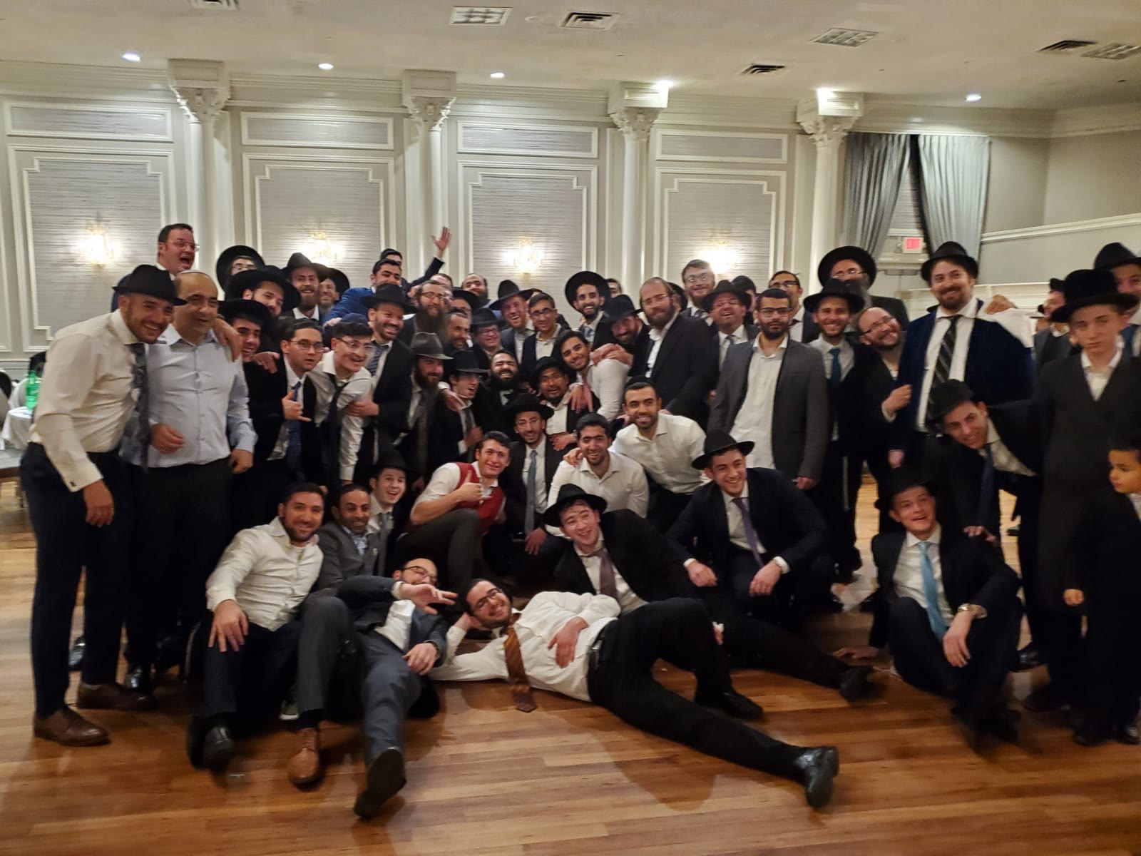 A large group photograph of talmidim and rebbeim at a simcha