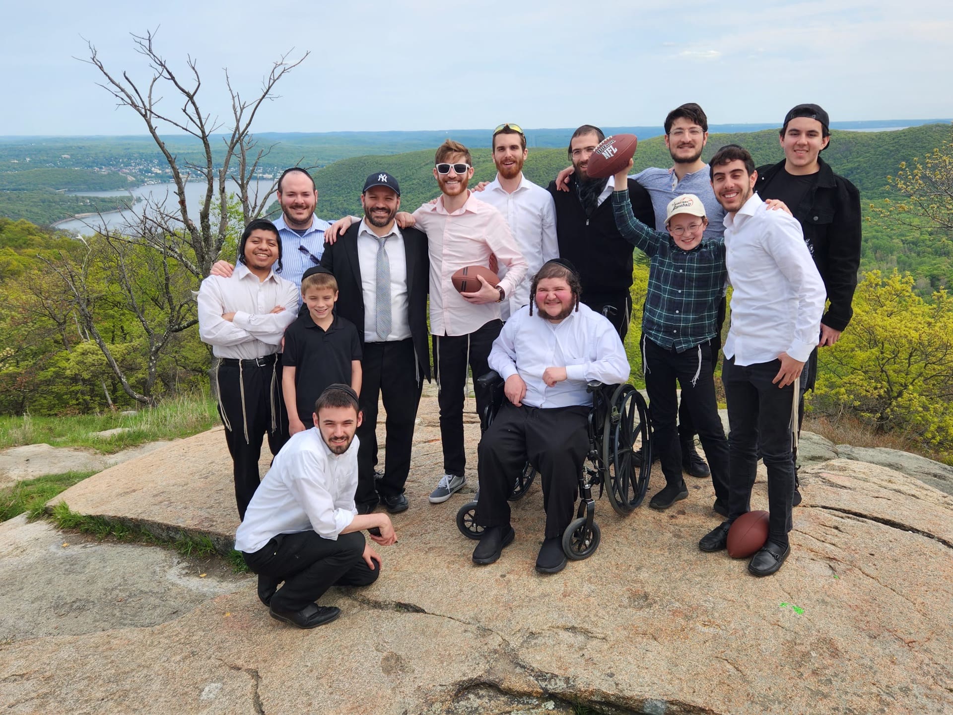 Talmidim posing on a rock overlooking the river and hills